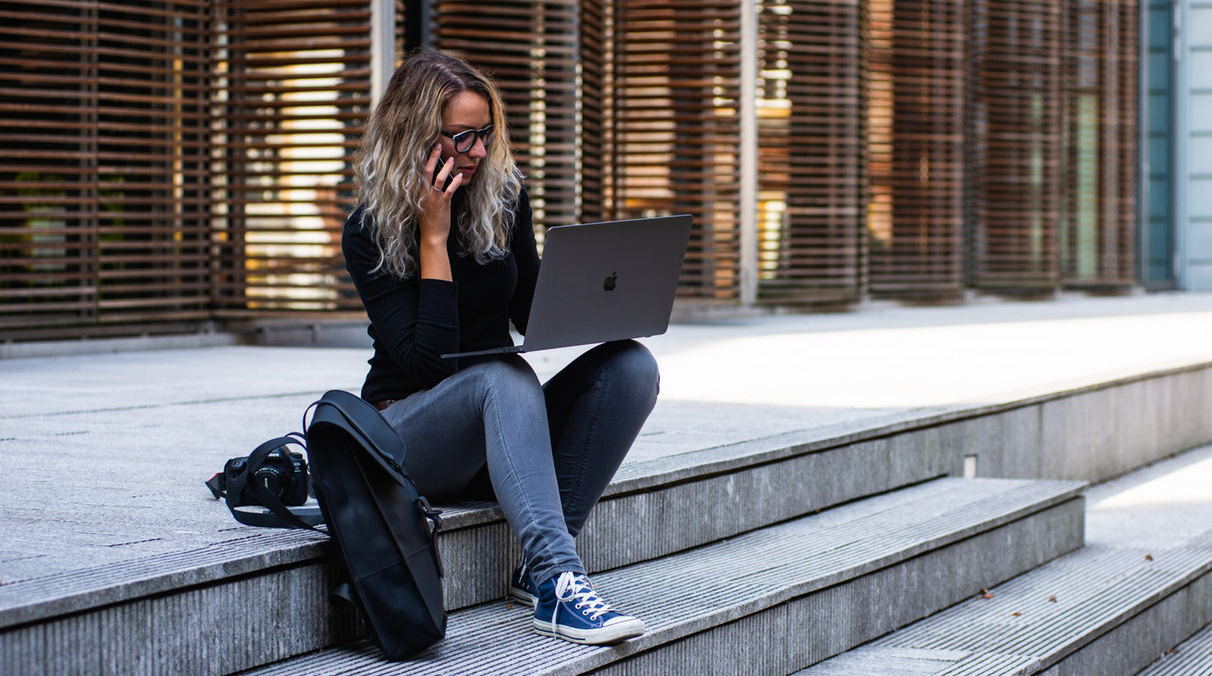 Women sitting on steps with a laptop