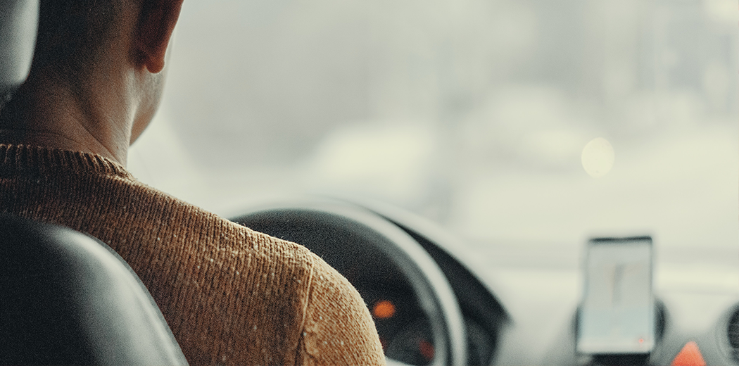 Man in car with navigation app on phone