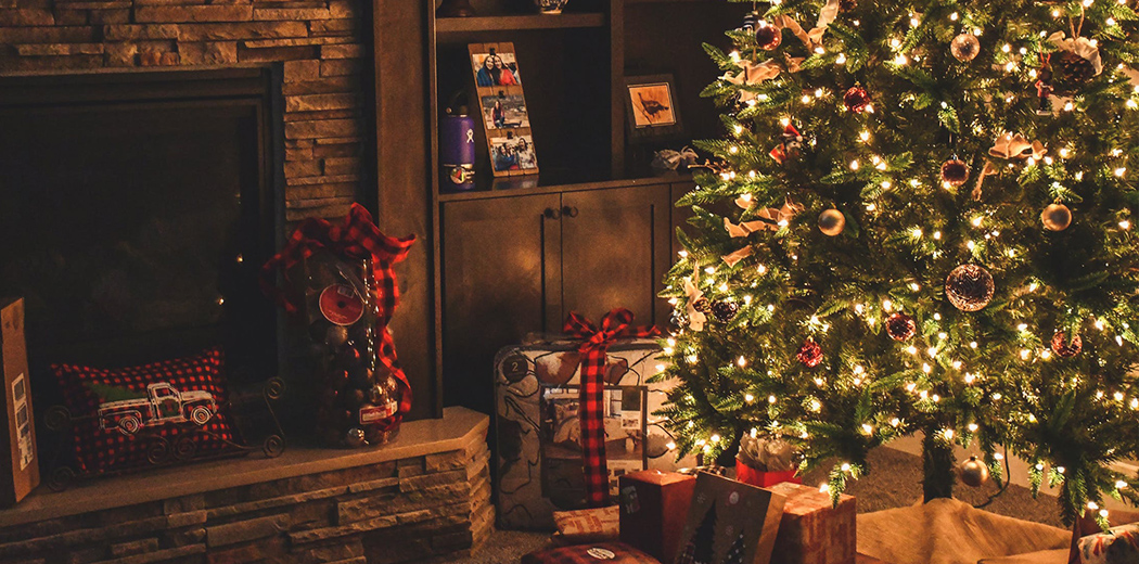 Christmas tree and presents next to fireplace