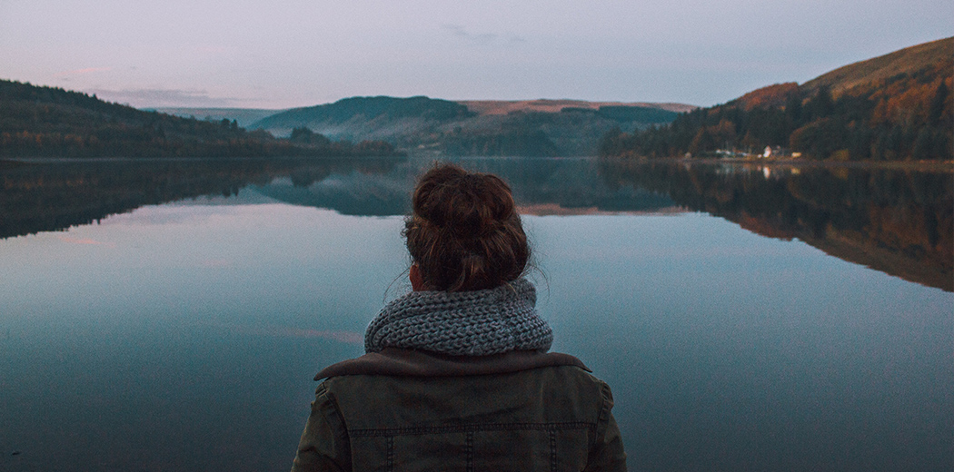 women staring at lake